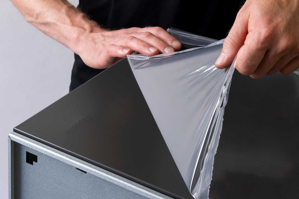 man removing film from box